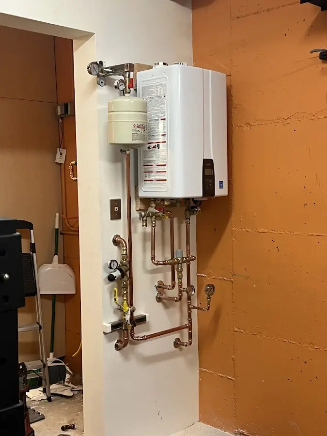 Plumbing technician inspecting water heater connections in Shorewood